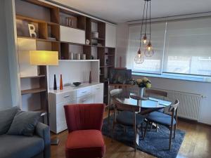 a living room with a table and a dining room at Apartman Pionirska dolina in Sarajevo