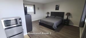 una camera da letto con un letto e una televisione di Tay Motel a Waubaushene