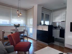 a living room with a table and a kitchen at Apartman Pionirska dolina in Sarajevo
