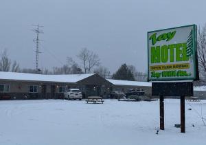 un cartello nella neve davanti a un edificio di Tay Motel a Waubaushene