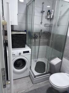 a bathroom with a washing machine and a shower at Apartman Pionirska dolina in Sarajevo