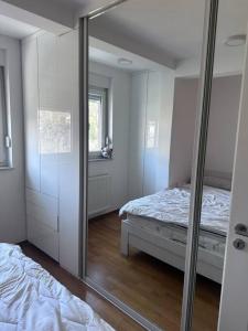 a mirror in a room with a bed and a bedroom at Apartman Pionirska dolina in Sarajevo