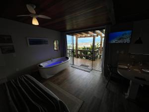 uma casa de banho com uma banheira, um lavatório e uma televisão em Chalés e Bangalôs Ibiraquera em Praia do Rosa