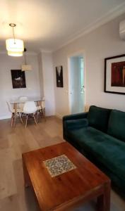 sala de estar con sofá verde y mesa en Apartamento Celia, en Sevilla