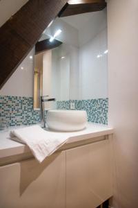 La salle de bains est pourvue d'un lavabo et d'un miroir. dans l'établissement Les Chambres du "Coup de Coeur de Sarlat", à Sarlat-la-Canéda