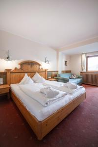 una grande camera da letto con un grande letto in legno di Das Posthaus stubai&smart Hotel a Fulpmes