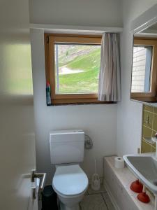 a bathroom with a white toilet and a window at *TOP* moderne Wohnung im Herzen von Andermatt in Andermatt