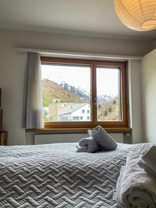 a bedroom with a bed with a large window at *TOP* moderne Wohnung im Herzen von Andermatt in Andermatt