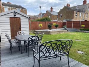 a patio with a table and chairs on a deck at Belle-Vue Apartments in Hunstanton