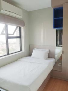 a white bedroom with two beds and a window at AMI POLARIS 23 Apartment-Residence in Phnom Penh