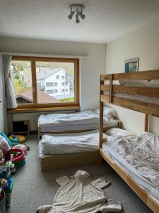 安德馬特的住宿－*TOP* moderne Wohnung im Herzen von Andermatt，一间卧室设有两张双层床和一扇窗户。