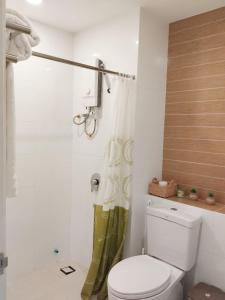 y baño con aseo y cortina de ducha. en AMI POLARIS 23 Apartment-Residence en Phnom Penh