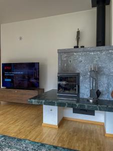 sala de estar con chimenea y TV de pantalla plana en *TOP* moderne Wohnung im Herzen von Andermatt en Andermatt