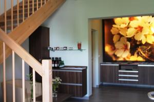 a living room with a large tv and a staircase at Ferienhof Weingut Lunzer in Gols