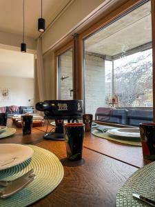a living room with a table and a large window at *TOP* moderne Wohnung im Herzen von Andermatt in Andermatt