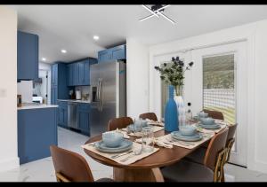 cocina con mesa de madera y armarios azules en Chic Naples cottage 7 min from the beach en Naples