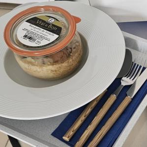 a white plate with a container of food on it at Escal Hôtel in Étaples
