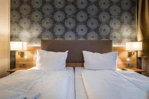 2 łóżka z białymi poduszkami w pokoju hotelowym w obiekcie Hotel Alter Markt w Berlinie