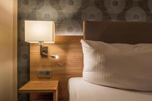 a bedroom with a bed with a lamp and a side table at Hotel Alter Markt in Berlin