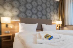 um quarto com uma cama branca e toalhas em Hotel Alter Markt em Berlim
