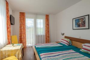 Habitación de hotel con 2 camas y ventana en Bed & Breakfast Eckwirt en Sankt Kanzian
