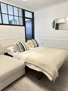 two beds in a white room with a window at Beautiful Converted Brewery in Newport