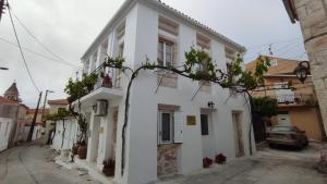 un edificio blanco con plantas a su lado en Xenonas "Alexandra's Coffee House" en Volímai