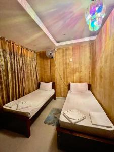 two beds in a room with a ceiling at Airport City Hotel in Katunayake