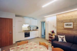 cocina y sala de estar con sofá y mesa en Appartamento Cembro, en Ossana