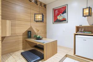 een kamer met een bureau en een koelkast bij Hotel Coqueiros 6 in Carapicuíba