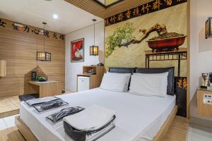 ein Schlafzimmer mit einem großen Bett und einem Gemälde an der Wand in der Unterkunft Hotel Coqueiros 6 in Carapicuíba