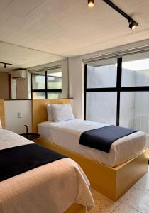 2 camas en una habitación con ventana en Cardedeu Express Hotel, en San Salvador