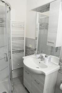 une salle de bain blanche avec un lavabo et une douche dans l'établissement Appartamento Il Limone, à Pise
