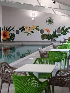 um restaurante com piscina, mesas e cadeiras em Escape to Paradise at Pevensey Bay Holiday Park 13 Woodland Walk em Pevensey