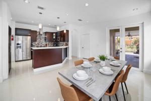 - une salle à manger et une cuisine avec une table et des chaises dans l'établissement Ohana House Jacuzzi Pool and Ping Pon Terrace, à Homestead
