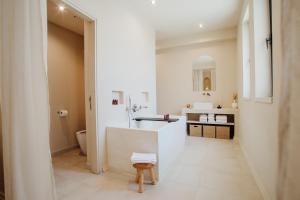 a white bathroom with a sink and a toilet at Thymises Boutique Hotel in Kakopetria