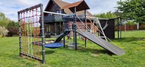 a playground with a slide in front of a house at Ostoja pod Orlami in Kołczewo