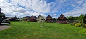 a row of houses with trees in a yard at Ostoja pod Orlami in Kołczewo