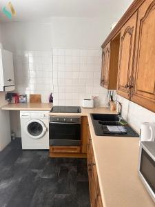 a kitchen with a stove and a washing machine at Milton Road Flat 2 - TSAC in Hartlepool