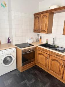 a kitchen with a sink and a washing machine at Milton Road Flat 2 - TSAC in Hartlepool