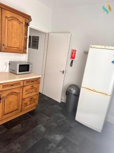 a kitchen with a white refrigerator and a microwave at Milton Road Flat 2 - TSAC in Hartlepool