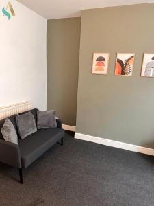 sala de estar con sofá y pinturas en la pared en Milton Road Flat 1 - TSAC, en Hartlepool