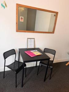 una mesa negra con 2 sillas y un espejo en Milton Road Flat 1 - TSAC, en Hartlepool