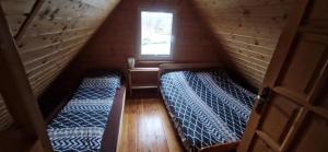 two beds in a small room with a window at Ostoja pod Orlami in Kołczewo