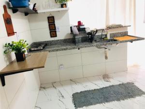 uma cozinha com uma bancada em mármore e um lavatório em lindo apartamento no recreio bem pertinho da praia no Rio de Janeiro