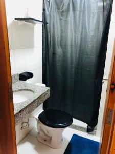 uma casa de banho com uma cortina de chuveiro preta e um WC. em lindo apartamento no recreio bem pertinho da praia no Rio de Janeiro