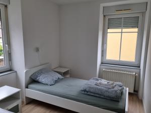 ein kleines Schlafzimmer mit einem Bett und einem Fenster in der Unterkunft Le Tournesol, Appartement T1 bis in Héricourt