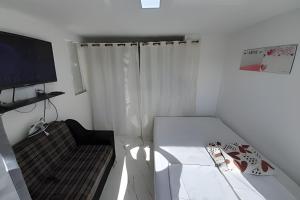 lindo apartamento no recreio bem pertinho da praia في ريو دي جانيرو: غرفة صغيرة فيها سرير وتلفزيون