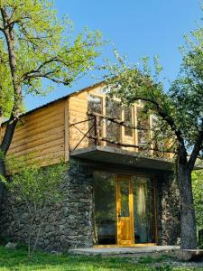 a stone house with a balcony on top of it at Guest House Aleksandre in T'mogvi