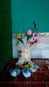 deux bols bleus et blancs avec un bouquet de fleurs dans l'établissement Let's go CAN THO - CAN THO FARMSTAY, à Ấp Phú Thạnh (4)